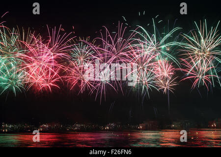 D'artifice colorés reflètent sur l'eau de mer Banque D'Images