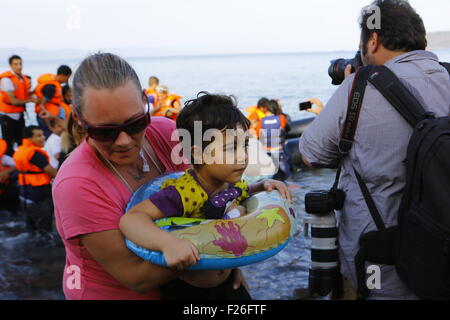 Lesbos, Grèce. 09Th Nov, 2015. Un bénévole a une fille à la rive de Lesbos. Des centaines de réfugiés, principalement en provenance de Syrie, l'Irak et l'Afghanistan sont encore à venir à l'île grecque de Lesbos sur une base quotidienne, après avoir fait le périlleux voyage de la côte turque en petits bateaux gonflables. © Michael Debets/Pacific Press/Alamy Live News Banque D'Images