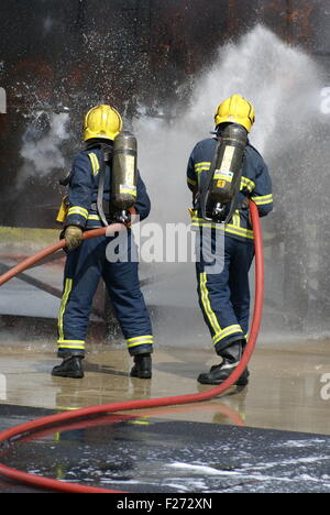 La lutte contre l'incendie pompier industriel avec flexible Banque D'Images