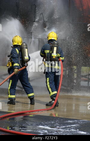 Lutte contre l'incendie Les pompiers avec flexible Banque D'Images