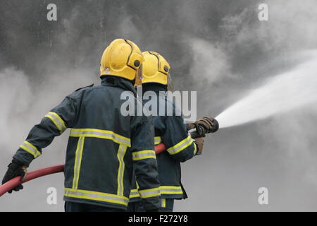 Lutte contre l'incendie Les pompiers avec flexible Banque D'Images