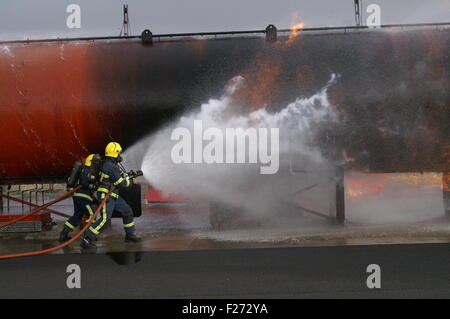 Les pompiers combattre le feu avec le tuyau Banque D'Images