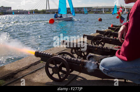 Pistolet traditionnel de course de yacht, flash de poudre noir de tir et canon de finition sur le quai à Southport, Merseyside, Royaume-Uni.La course de yacht de 24 heures de Southport est une course nationale d'endurance à la voile pour les dinghies de voile à deux mains, avec 63 bateaux Firefly, Lark, Enterprise et GP 14 en compétition.La course, organisée par le West Lancs Yacht Club, a une longue histoire et se tient habituellement en septembre.La course commence à 12 heures le samedi.Les concurrents font ensuite la course de leurs dinghies autour du lac marin, qui se termine à midi le lendemain, accompagné d'une forte bangs et fumée. Banque D'Images