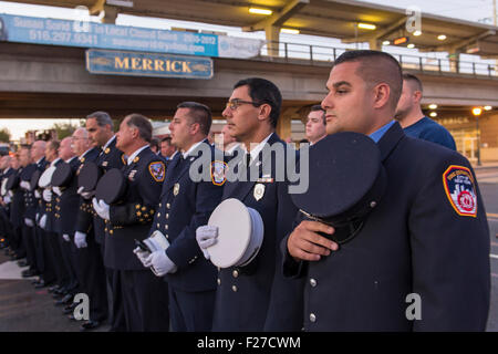 Merrick, New York, USA. 11 septembre 2015. Les pompiers de Merrick et New York City la queue et tenir leur casquette sur le coeur au cours de Merrick Merrick Cérémonie commémorative pour les pompiers volontaires et les résidents qui sont morts en raison d'attentats terroristes à New York Tours Jumelles. Ex-Chief Ronnie E. Gies, du Merrick F.D. et FDNY Squad 288 Ex-Captain, et Brian E. Sweeney, du Merrick F.D. et FDNY Rescue 1, est mort en réponse à des attaques du 11 septembre 2001. Credit : Ann E Parry/Alamy Live News Banque D'Images