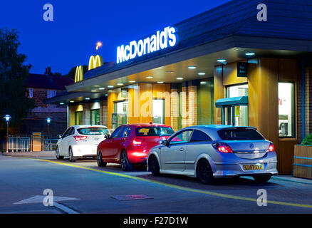 La file de voitures chez McDonald's restaurant drive-in, de nuit, en Angleterre, Royaume-Uni Banque D'Images