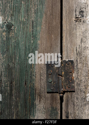 Old rusty sur charnière de porte en bois porte en bois vert Banque D'Images