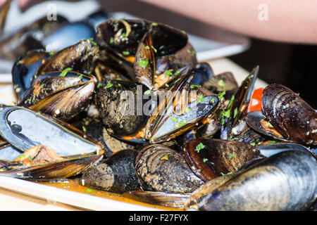 Un plat de moules des photos avec la sauce tomate, ouvert, prêt à manger, d'une table se propager. Banque D'Images