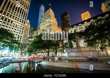 Le Pulitzer Fontaine à Grand Army Plaza et des bâtiments dans le centre de Manhattan de nuit à New York. Banque D'Images