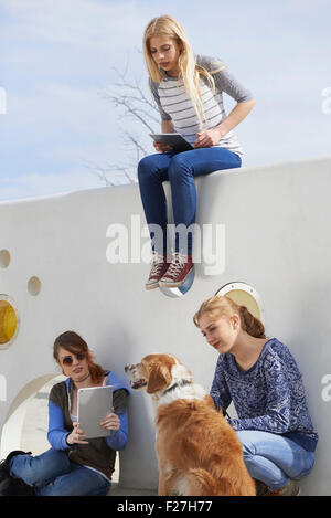 Trois amis dans une aire de jeux avec chien, Munich, Bavière, Allemagne Banque D'Images