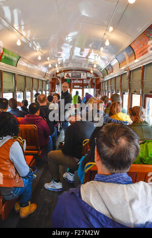 Passagers sont assis sur des bancs en bois classique à bord du célèbre tramway Saint-charles à New Orleans, LA Banque D'Images