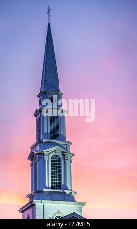 Grande, blanche, clocher de l'église contre un ciel coucher de soleil coloré. Banque D'Images