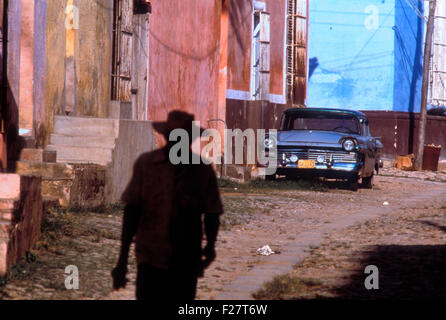 Un homme marche dans une ruelle devant une vieille Ford à La Havane, Cuba. Banque D'Images