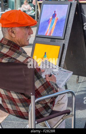 Une personne âgée de 80 à 90 ans se trouve votre artiste et attendre que les clients qu'il affiche des peintures dans l'Union Square, San Francisco Banque D'Images