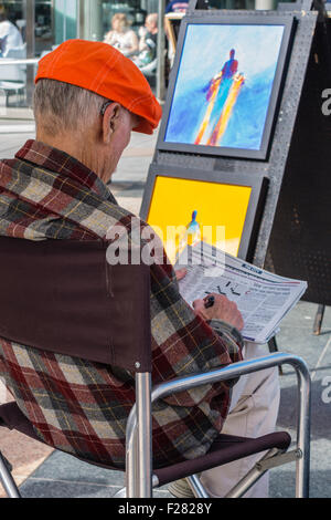 Une personne âgée de 80 à 90 ans se trouve votre artiste et attendre que les clients qu'il affiche des peintures dans l'Union Square, San Francisco Banque D'Images