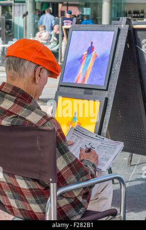 Une personne âgée de 80 à 90 ans se trouve votre artiste et attendre que les clients qu'il affiche des peintures dans l'Union Square, San Francisco Banque D'Images