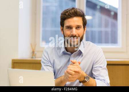 Confiant bearded businessman with hands clasped Banque D'Images