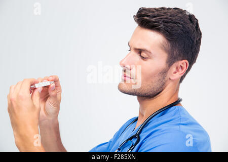 Portrait d'un beau mâle médecin à thermomètre sur isolé sur fond blanc Banque D'Images