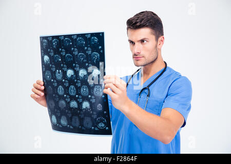 Portrait of a male doctor looking at x-ray photo de cerveau isolé sur fond blanc Banque D'Images