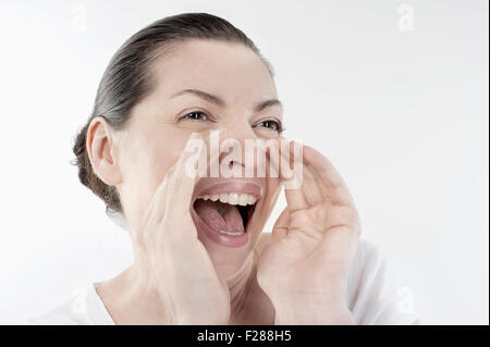 Femme mature de crier et hurler isolated over white background, Bavière, Allemagne Banque D'Images