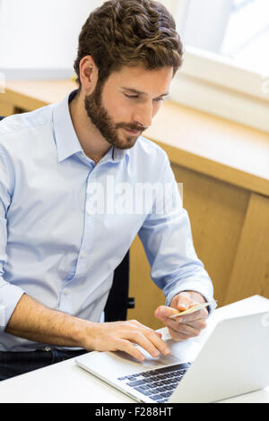 L'homme d'affaires occasionnels de payer en ligne par carte de crédit. Banque D'Images