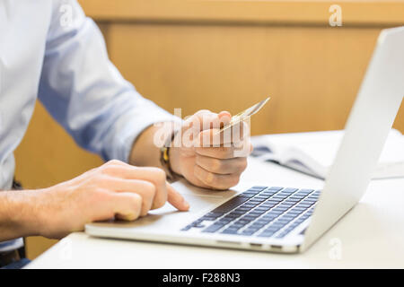 L'homme d'affaires occasionnels de payer en ligne par carte de crédit. Banque D'Images