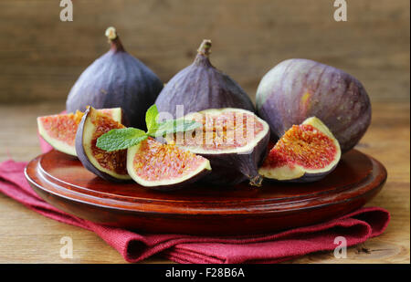 Produits frais bio de figue violette sur plaque de bois Banque D'Images