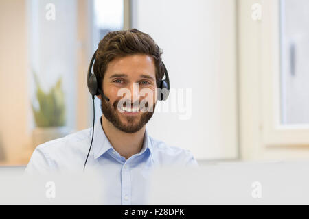 Portrait d'homme barbu avec casque au bureau Banque D'Images