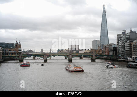 Vue en direction de Tower bridge Londres avec un bateau de plaisance croisières ville en premier plan Banque D'Images