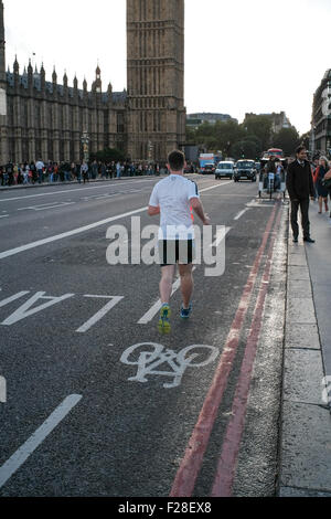 Un coureur solitaire de Westminster Bridge London s'exécutant dans la voie cyclable Banque D'Images