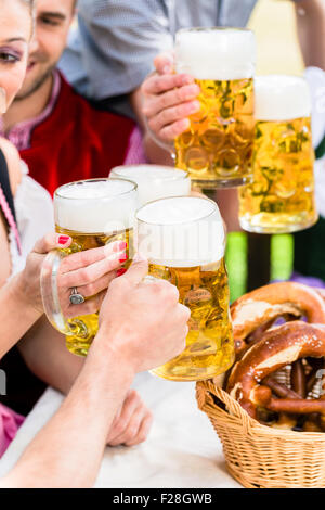 Clinking glasses with beer in Bavarian pub Banque D'Images