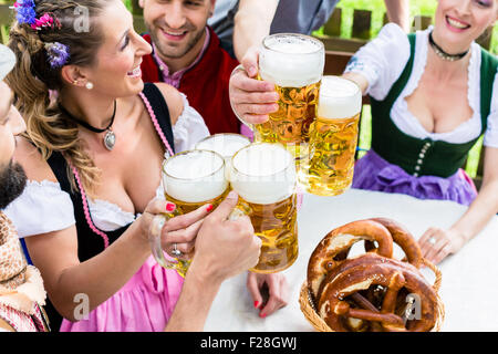 Clinking glasses with beer in Bavarian pub Banque D'Images