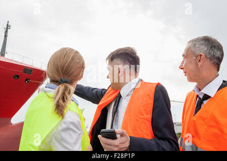 Les gens d'affaires regardant le cargo au port, Hambourg, Allemagne Banque D'Images