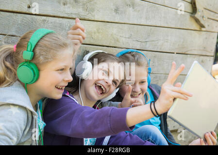 Trois amis assis dans une aire de jeux et d'écoute de la musique, Munich, Bavière, Allemagne Banque D'Images