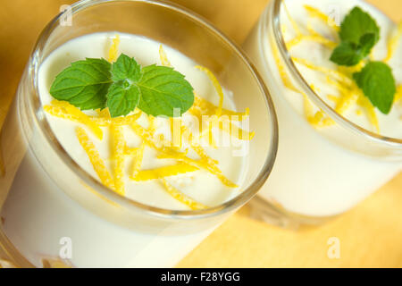 Panacotta vanille dessert avec du citron et de la menthe fraîche en lunettes partie close up Banque D'Images