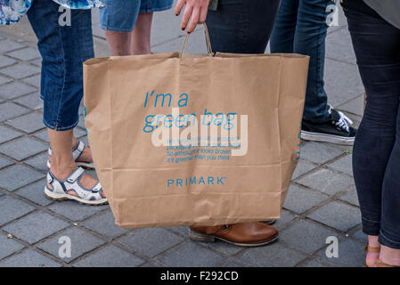 Un client détenant un Primark 'Green' sac de papier fabriqué à partir de carton recyclé et les sacs en papier. Banque D'Images