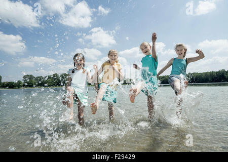 Groupe d'amis aux projections d'eau dans le lac, Bavière, Allemagne Banque D'Images