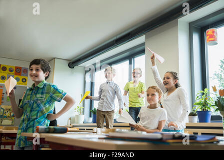 Écoliers jouant avec des avions en papier en classe, Munich, Bavière, Allemagne Banque D'Images