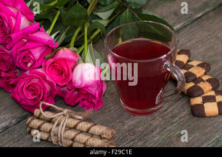 Bouquet de belles roses, divers témoins et tasse de thé Banque D'Images