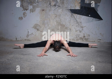 Mid adult woman practicing assis grand angle de flexion avant de poser dans un studio de yoga, Munich, Bavière, Allemagne Banque D'Images