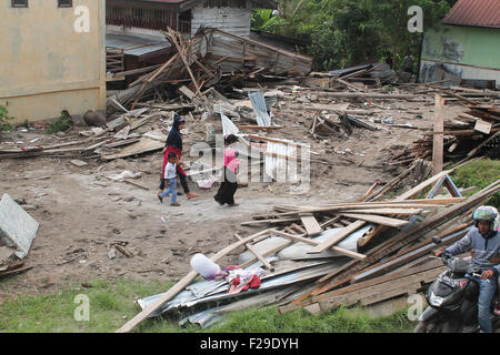 Lhokseumawe, Indonésie. 14Th Sep 2015. Passant à la résidents ruines de maisons endommagées par l'inondation dans le village Fajar harapan. Les crues éclair dans les highlands Gayo provoqué des pluies torrentielles et des cours d'eau abondants à l'origine de 149 personnes déplacées et des maisons endommagées. Credit : Fach Reza/Pacific Press/Alamy Live News Banque D'Images