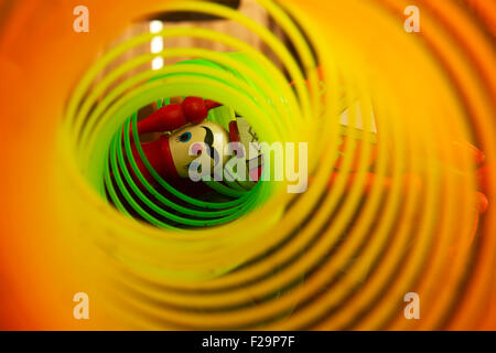Homme de bois et de couleur arc-en-jouet slinky jouet constitué d'un fil en plastique bobine spiralée qui permet la flexibilité et de la mobilité Banque D'Images