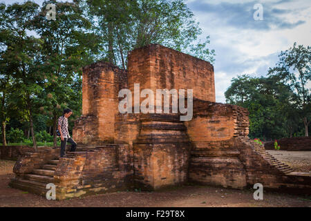 Un villageois pose pour une photo au temple Gedong I dans les compounds du temple de Muara Jambi à Muaro Jambi, Jambi, Indonésie. Banque D'Images