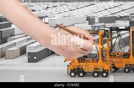 Travel Concept - la main avec des peintures pinceau grue orange dans le port du fret Banque D'Images