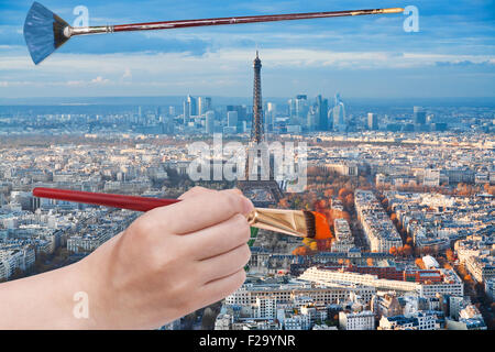 Travel Concept - la main avec pinceau peint en orange les arbres à proximité de la tour Eiffel à Paris, France Banque D'Images