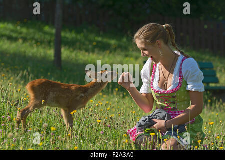 Une jeune femme avec le chevreuil (Capreolus capreolus) qui avait été élevé, Tyrol, Autriche Banque D'Images