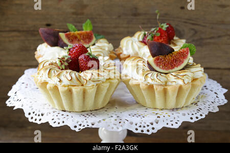 Dessert tartelettes de pâte brisée avec de la meringue et les fruits Banque D'Images