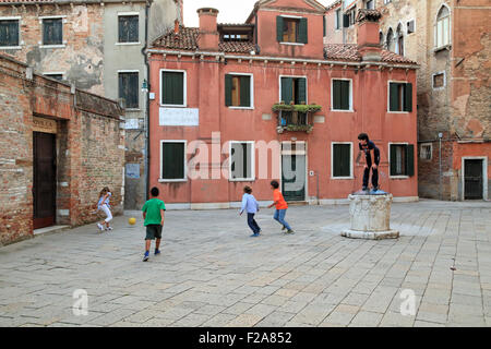 Les enfants jouent au football à Venise Campo de le Strope Banque D'Images
