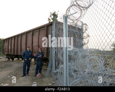 Roeszke, Hongrie. 15 Sep, 2015. La police hongroise sont affectés à la garde de la dernière section de la clôture frontalière à côté d'un wagon de marchandises entre la Hongrie et la Serbie, près de Roeszke, Hongrie, le 15 septembre 2015. Le wagon a été déplacé en position pour combler l'écart dans la dernière section de la 175 kilomètre de long clôture le long de la frontière entre la Serbie et la Hongrie. Photo : Thomas Brey/dpa/Alamy Live News Banque D'Images