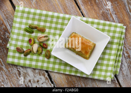 Baklava aux pistaches dans un bol blanc sur tissu à carreaux Banque D'Images
