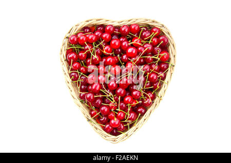 Les cerises mûres en forme du cœur panier en osier isolated on white Banque D'Images